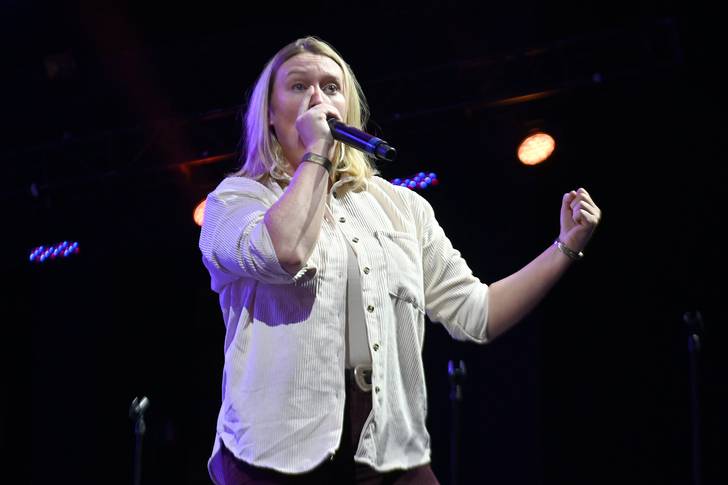 A woman onstage using a microphone.